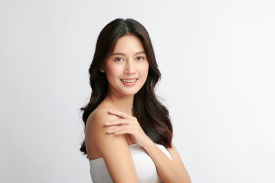 美丽年轻的亚洲女性与干净的新鲜皮肤在白色的背景，面部护理，面部治疗，美容和水疗中心，亚洲女性肖像。