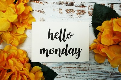 Hello Monday卡片与盛开的花在木制背景