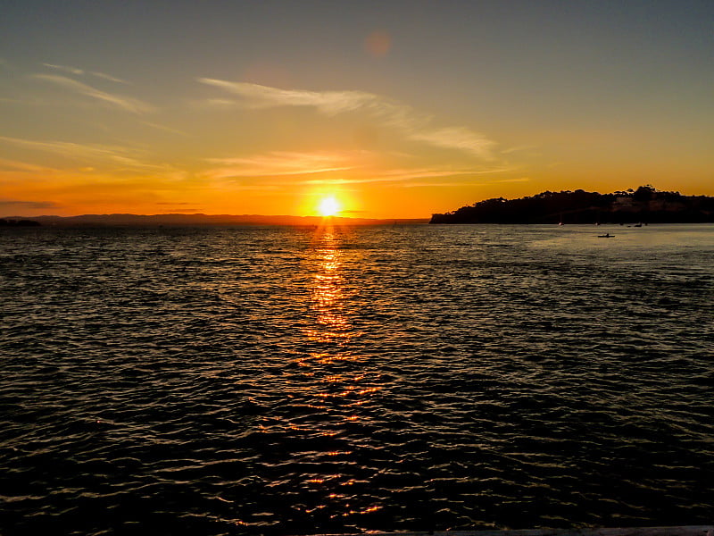 日落时分，在伯肯黑德码头附近的铁湾上夕阳西下。奥克兰,新西兰