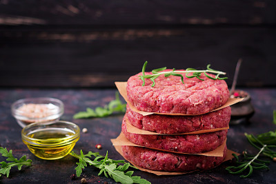 新鲜的生自制牛肉碎汉堡与香料在黑色的背景