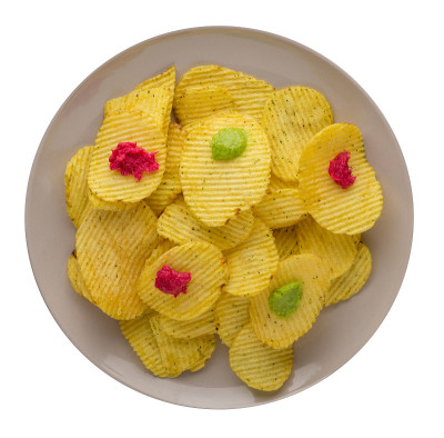 土豆片放在盘子里。在白色背景上孤立的薯片。垃圾食品