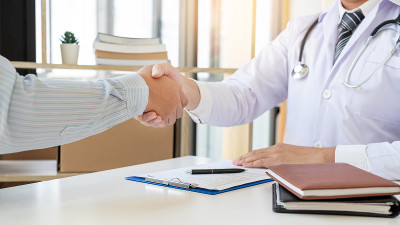 医学保健和信任的理念，医生与病人同事握手后谈论医学检查结果