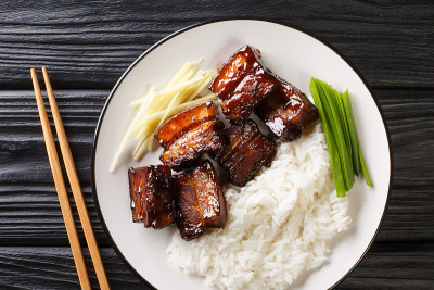 “Rafute”是冲绳版的炖五花肉，盘中有米饭。水平的俯视图