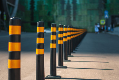 道路上有一排黄色护栏，把交通线和步行区隔开。