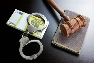 法官的木槌，手铐，欧元现金和书在黑桌上