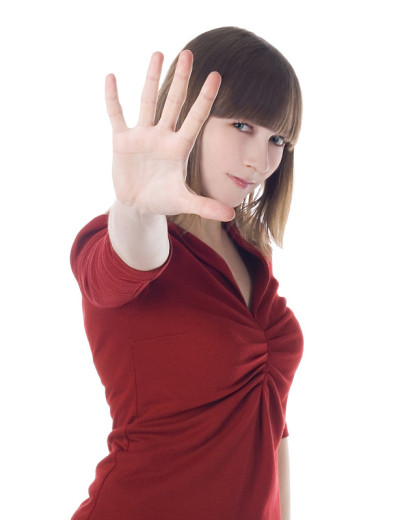 可爱的女人穿着红色衣服显示停止标志