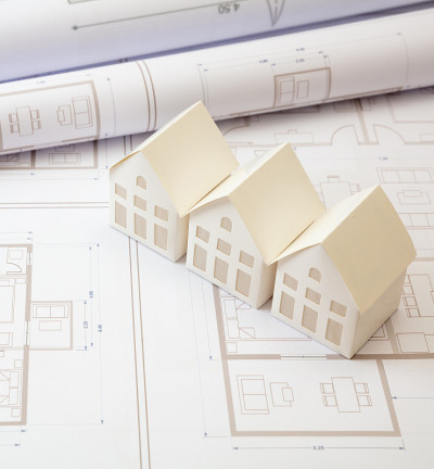 建筑的概念。办公桌上有住宅建筑图纸和建筑房屋模型