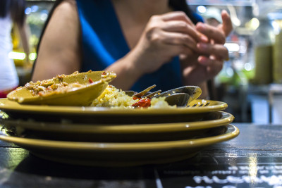 在泰国餐馆吃午餐。一个女人吃米饭和蔬菜和汤。