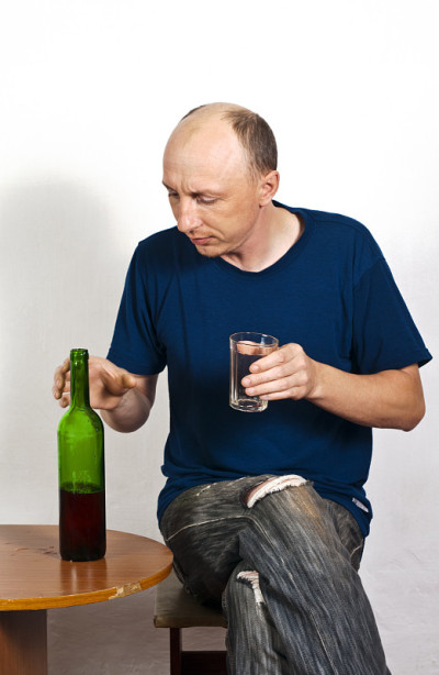 拿着酒杯和一瓶红酒的男人