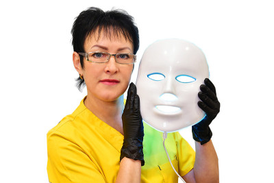 女美容师，带面罩，在孤立的背景下进行光疗