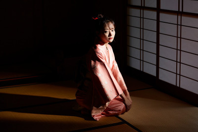 穿着和服的年轻女子坐在榻榻米垫子上