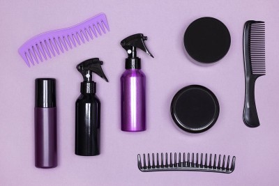 不同的头发护理和造型产品与梳子布局。俯视图，平躺