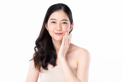 美丽年轻的亚洲女性与干净的新鲜皮肤在白色的背景，面部护理，面部治疗，美容和水疗中心，亚洲女性肖像。