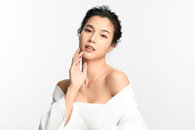 美丽年轻的亚洲女性与干净的新鲜皮肤在白色的背景，面部护理，面部治疗，美容和水疗中心，亚洲女性肖像。
