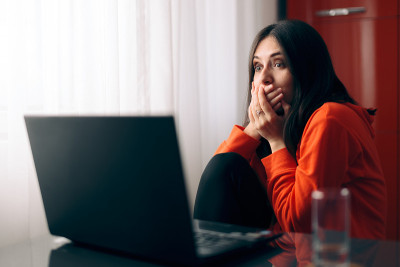 震惊的女人在网上阅读令人难以置信的新闻