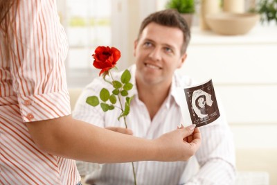 男子将玫瑰送给孕妇