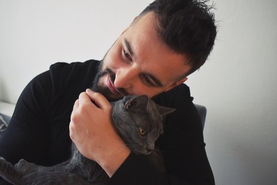 男人在室内拥抱他的猫
