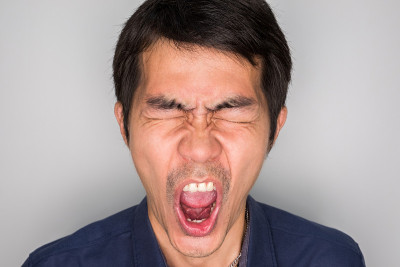 一个英俊的男人在愤怒的感觉。生气是一种消极的感觉。他在尖叫，大喊