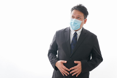 男人忍受着腹痛，戴着面具