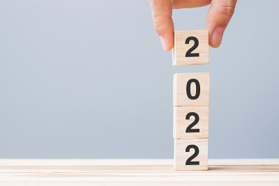 手握木立方体块与2022年的文本在桌子的背景。决心，计划，回顾，目标，开始和新年假期的概念