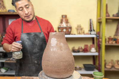 在他的工作室里，波特正在用纺车制造一艘船，他正在往船上喷水