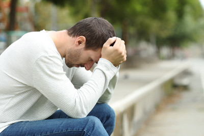 一个悲伤的成年男子独自在公园里抱怨