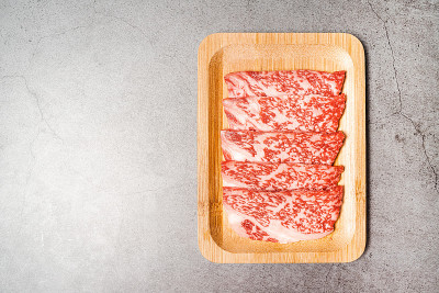 优质稀有切片牛腰和牛肉A5与高大理石纹理木盘。包括日式烧肉，寿喜烧和日式涮锅。带有复制空间的图像。