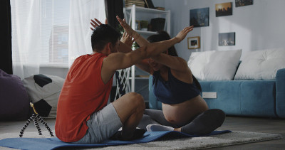 年轻男子指导孕妇健身
