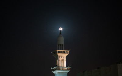 满月之夜清真寺尖塔的背景图像