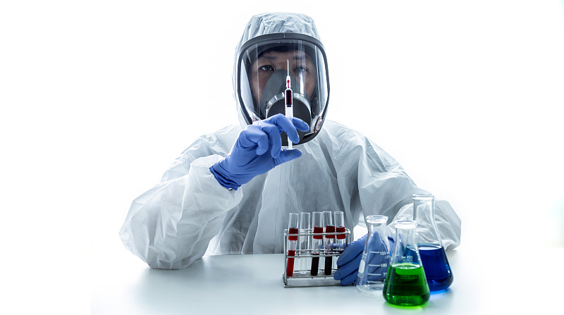 实验室技术员手里拿着注射器和血样。病毒的研究