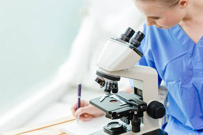 医科大学青年博士生在学校实验室用显微镜研究病毒疫苗。