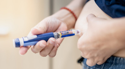 糖尿病患者手用胰岛素笔注射医疗设备在家中检查和控制糖尿病患者。