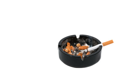 一个装有香烟的肮脏的黑色陶瓷烟灰缸
