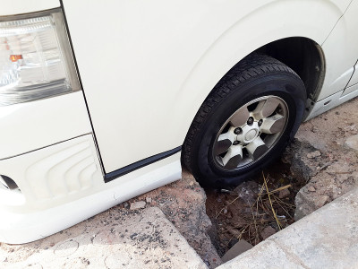 汽车被困在损坏的道路上。