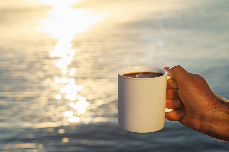 male hand with mug of coffee