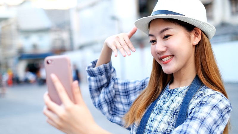 《亚洲旅行者》的博客女游客在泰国曼谷旅游，美丽的女性用手机制作视频博客并在社交媒体上生活。