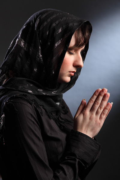 戴头巾的漂亮女人闭着眼睛祈祷