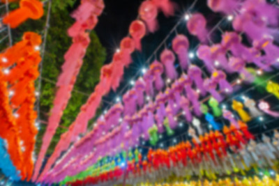 模糊的背景彩色纸灯笼挂着电线，树木和天空为背景