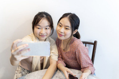 年轻的亚洲中国女孩用手机拍照