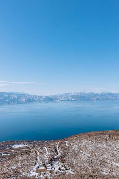 一个湖的景观在冬天与山和曲折的道路