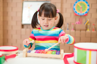 年轻女孩在家里弹奏木琴接受家庭教育
