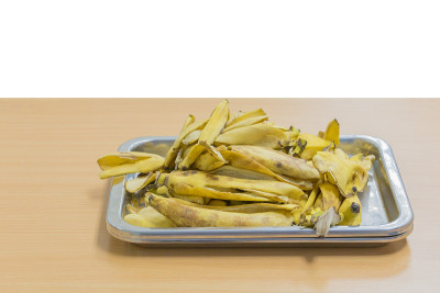 香蕉皮在托盘上的木桌与孤立的白色背景和剪切路径