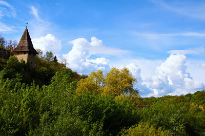 春天的风景。古老的石塔，木顶。蓝色的天空背景与云。景观和自然的概念