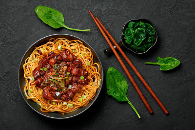 Bakmi或Mie Ayam在黑色的碗在深色的石板桌面上。印尼菜面条肉菜。传统的亚洲食物和餐点。俯视