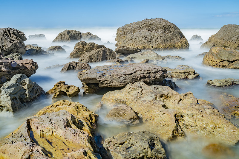 新西兰蒙加努伊山(Mount Maunganui)的崎岖海岸附近，海浪的激流变得平缓