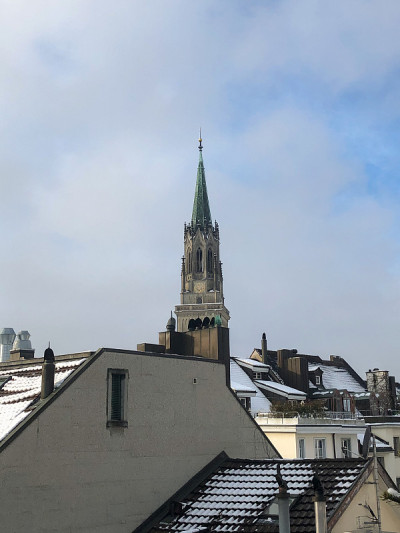 城市里的雪和背景里的天主教堂