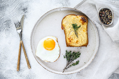 Croque Monsieur是一款传统法式烤奶酪火腿三明治，配白汁。白色背景。俯视图