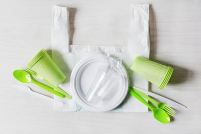 塑料一次性餐具。食物塑料木制背景俯视图。回收塑料和生态理念。塑料垃圾。