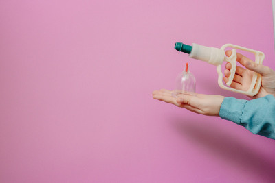 真空泵和罐的hijama。武器。在粉红色的背景上