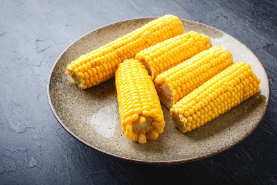 美味的煮玉米棒在盘子里